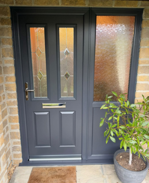 Anthracite grey solid core composite door with Classic leaded glass and a matching side panel with Stippolyte glass, fitted in a stone house in Tisbury, Wiltshire