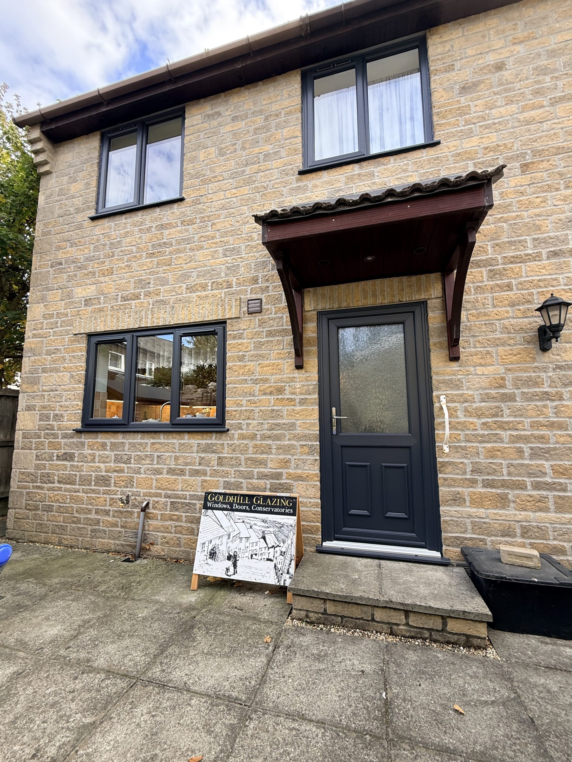 Anthracite grey composite door with a glazed top panel, fitted under a canopy in Tisbury